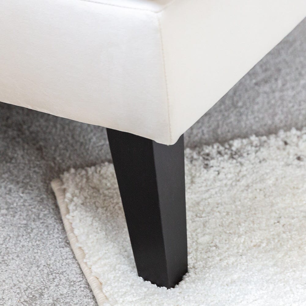 Fauteuil d'appoint en velours crème avec passepoil noir et pieds en bois foncé